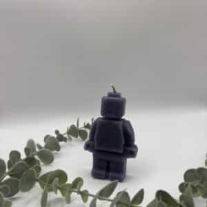 Een paarse kaars in de vorm van een legomannetje.