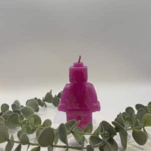 Een roze kaars in de vorm van een legomannetje.