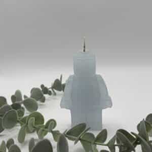 Een licht blauwe kaars in de vorm van een legomannetje.