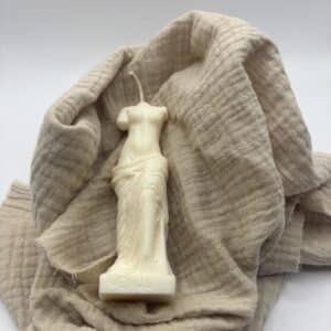 Een witte kaars in de vorm van een beeld van Venus zonder hoofd.