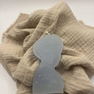 Een licht blauwe kaars in de vorm van een portret van een dame.