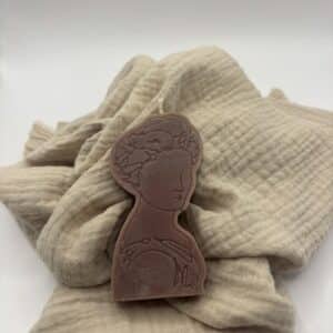 Een bordeaux kaars in de vorm van een portret van een dame.