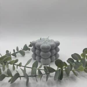 Een grijze kaars in de vorm van een kubus met hartjes.