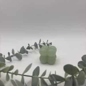 Een groene kaars in de vorm van een kleine kubus met bolletjes.