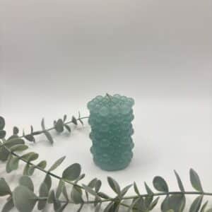 Een oud blauwe kaars in de vorm van een cilinder met bolletjes.