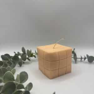 Een peach kaars in de vorm van een kubus.