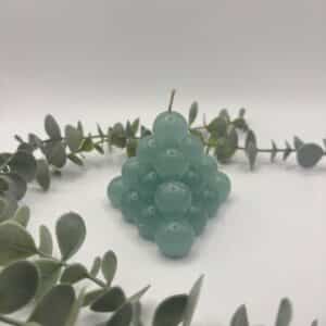 Een groene kaars in de vorm van een kleine piramide bestaande uit bolletjes.