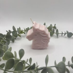 Een roze kaars in de vorm van een eenhoorn.