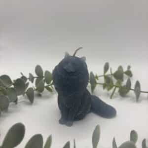 Een donker blauwe kaars in de vorm van een kat met manen.