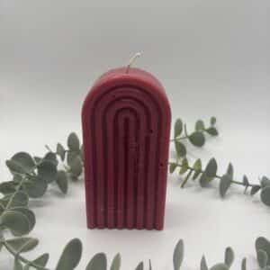 Een rode kaars in de vorm van een grote regenboog.