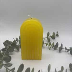 Een gele kaars in de vorm van een grote regenboog.