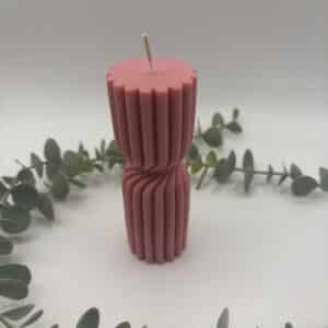 Een blush kaars in de vorm van een kleine pilaar met groeven.