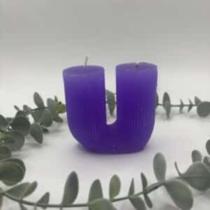 Een paarse kaars in de vorm van een U met groeven met twee lonten.