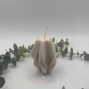 Een gebroken witte kaars in de vorm van een ster met krulletjes en groeven.