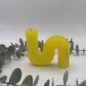 Een gele kaars in de vorm van een liggende S.