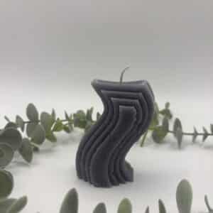 Een grijze kaars in de vorm van een golf.