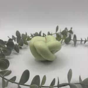 Een pistache kaars in de vorm van een knoop.