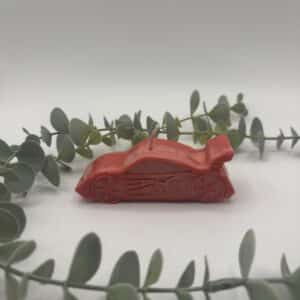 Een rode kaars in de vorm van een race auto.