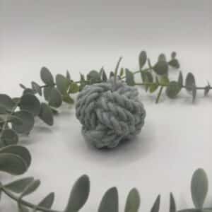 Een grijze kaars in de vorm van een bol sjortouw.