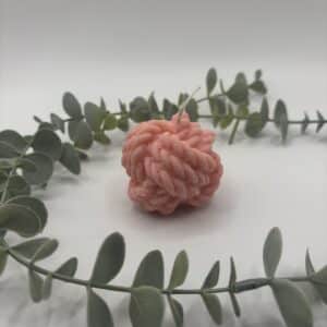 Een blush kaars in de vorm van een bol sjortouw.