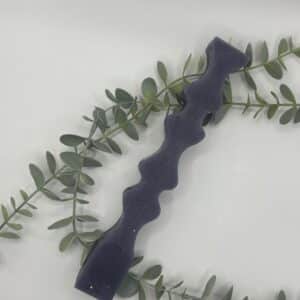 Een paarse kaars in de vorm van een pilaar met heupen.