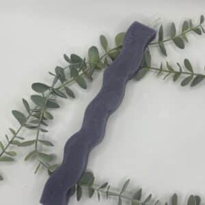 Een paarse kaars in de vorm van een pilaar met golven.