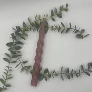 Een roze kaars voor een kandelaar met een geblokte krul in.