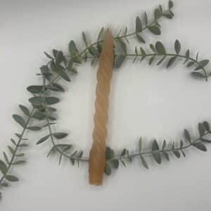 Een oranje kaars voor een kandelaar met een smalle krul in.