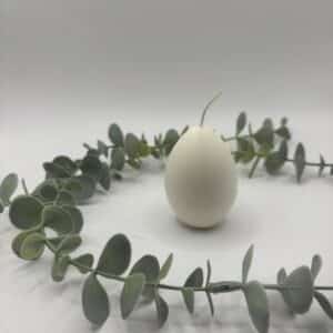 Een witte kaars in de vorm van een eitje.