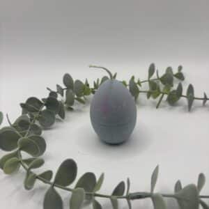 Een grijs-roze kaars in de vorm van een eitje.