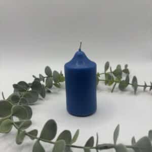 Een blauwe kaars in de vorm van een kleine cilinder.