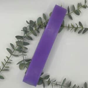 Een paarse kaars in de vorm van een vierkante pilaar.