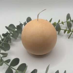 Een peach kaars in de vorm van een medium bol.