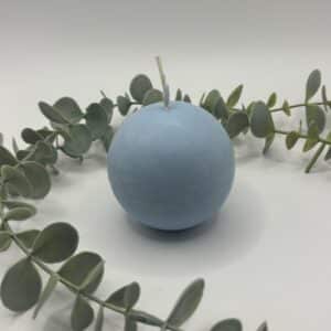 Een baby blauwe kaars in de vorm van een kleine bol.