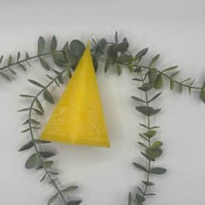 Een gele kaars in de vorm van een kleine piramide met vijf zijvlakken.