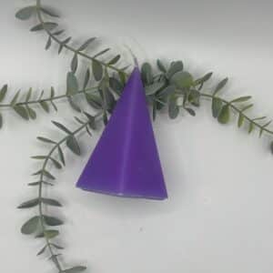 Een paarse kaars in de vorm van een kleine piramide met vijf zijvlakken.