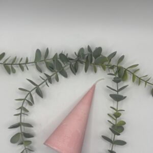Een baby roze kaars in de vorm van een kegel.